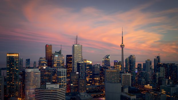 Capture of the Toronto skyline at sunset, highlighting modern skyscrapers and the CN Tower.
