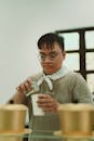 A man in glasses pouring coffee into a cup