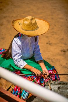 A girl dressed in traditional Mexican charro clothing at a rodeo event, Pachuca, Mexico.
