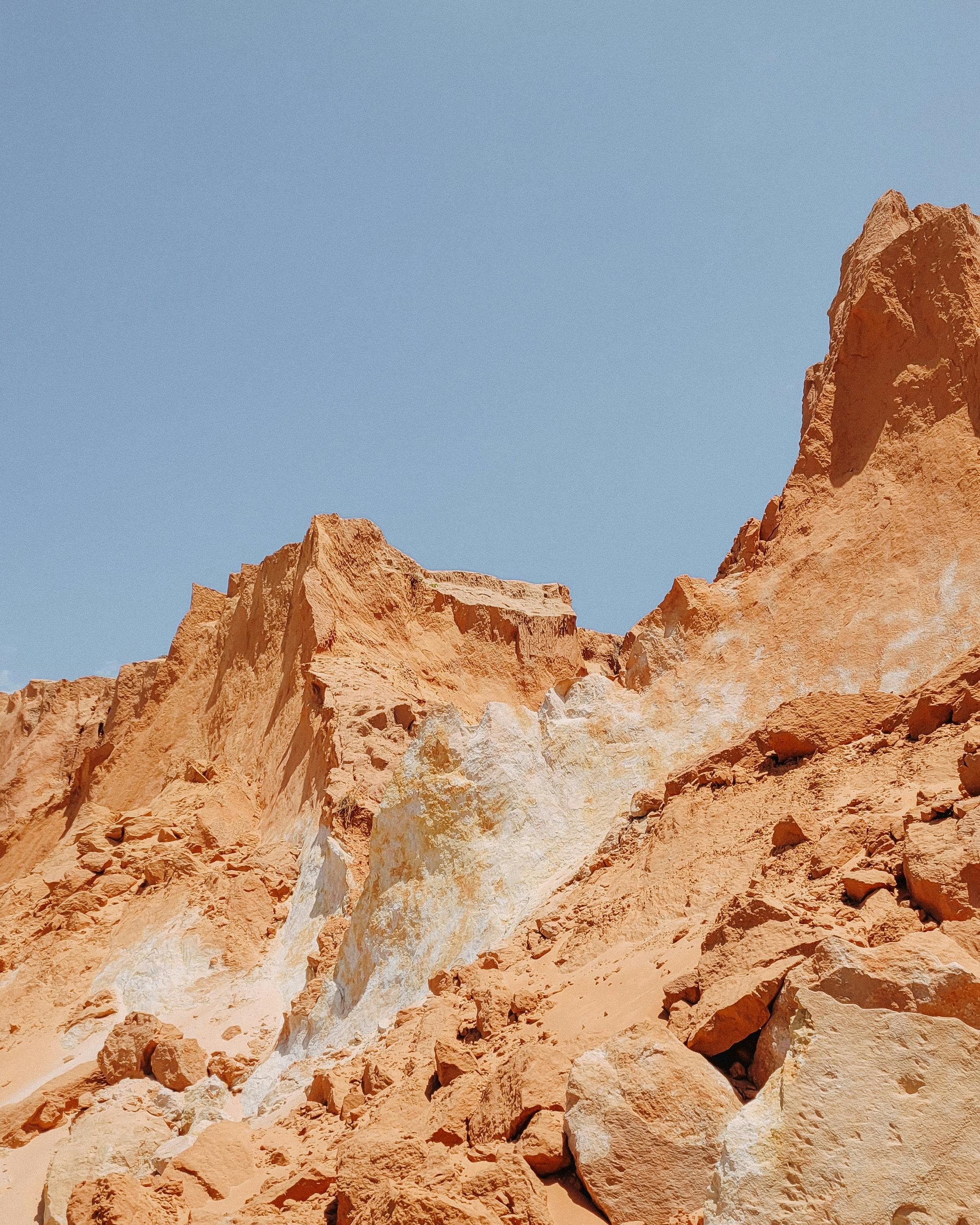Explore the stunning sandstone cliffs at Canoa Quebrada, Brazil, under a clear blue sky.