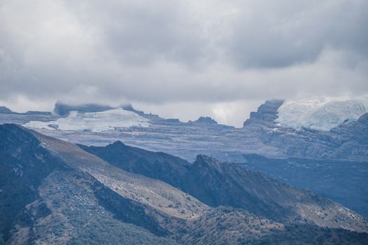 Breathtaking view of the Andes Mountains with glaciers and cloudy sky in El Cocuy National Park, Colombia.