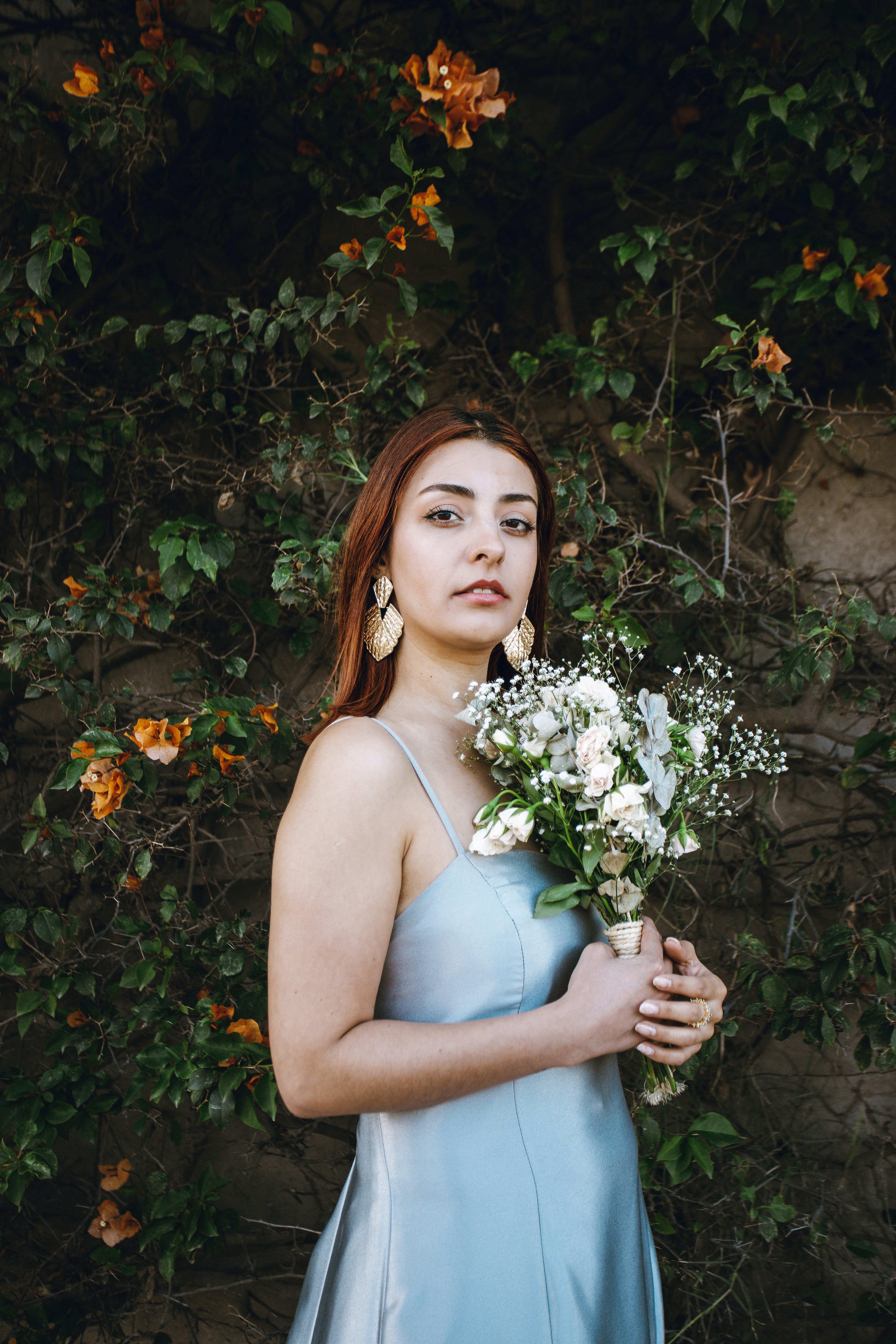 A woman in a blue dress holding a bouquet · Free Stock Photo