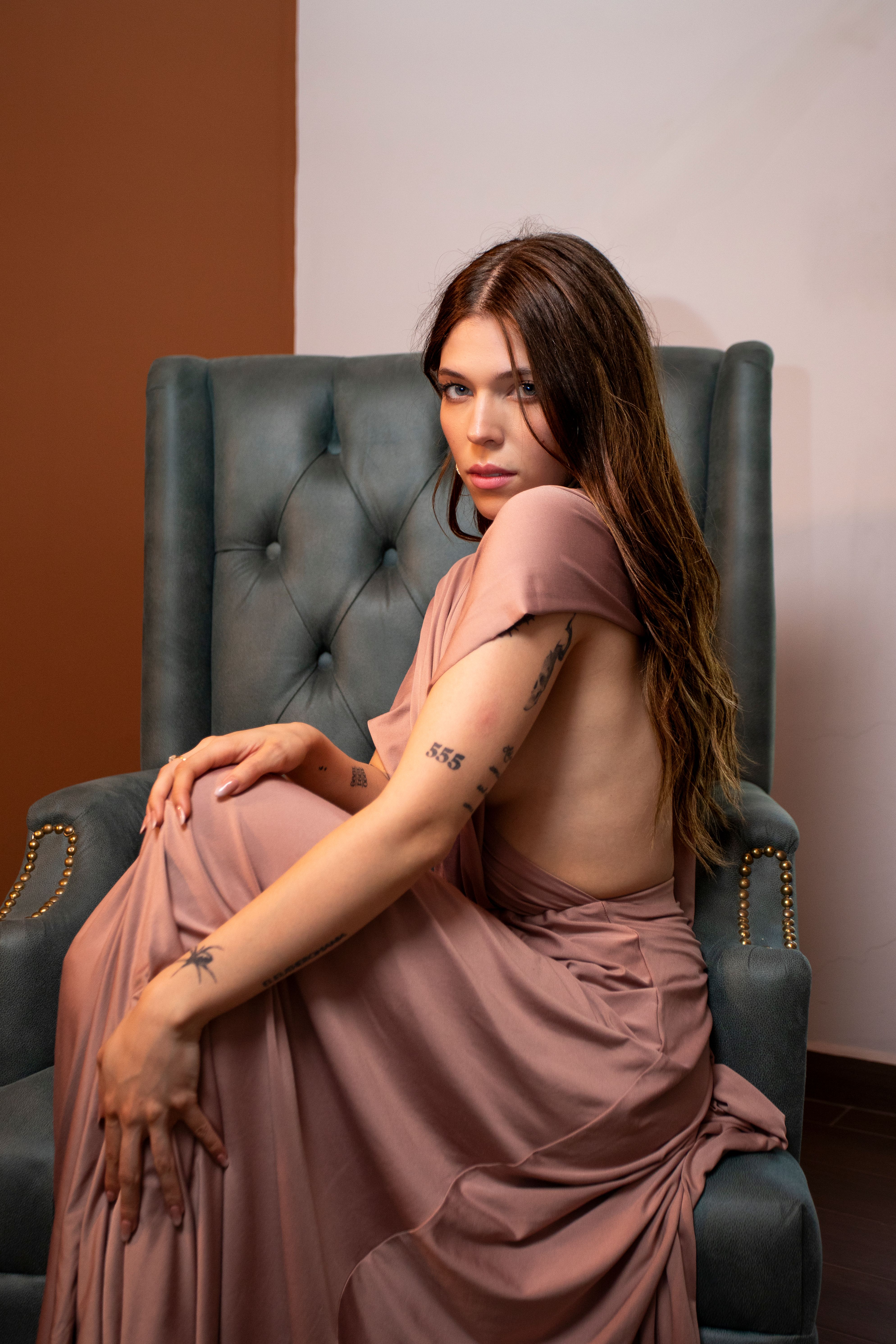 A woman in a pink dress sitting on a chair · Free Stock Photo
