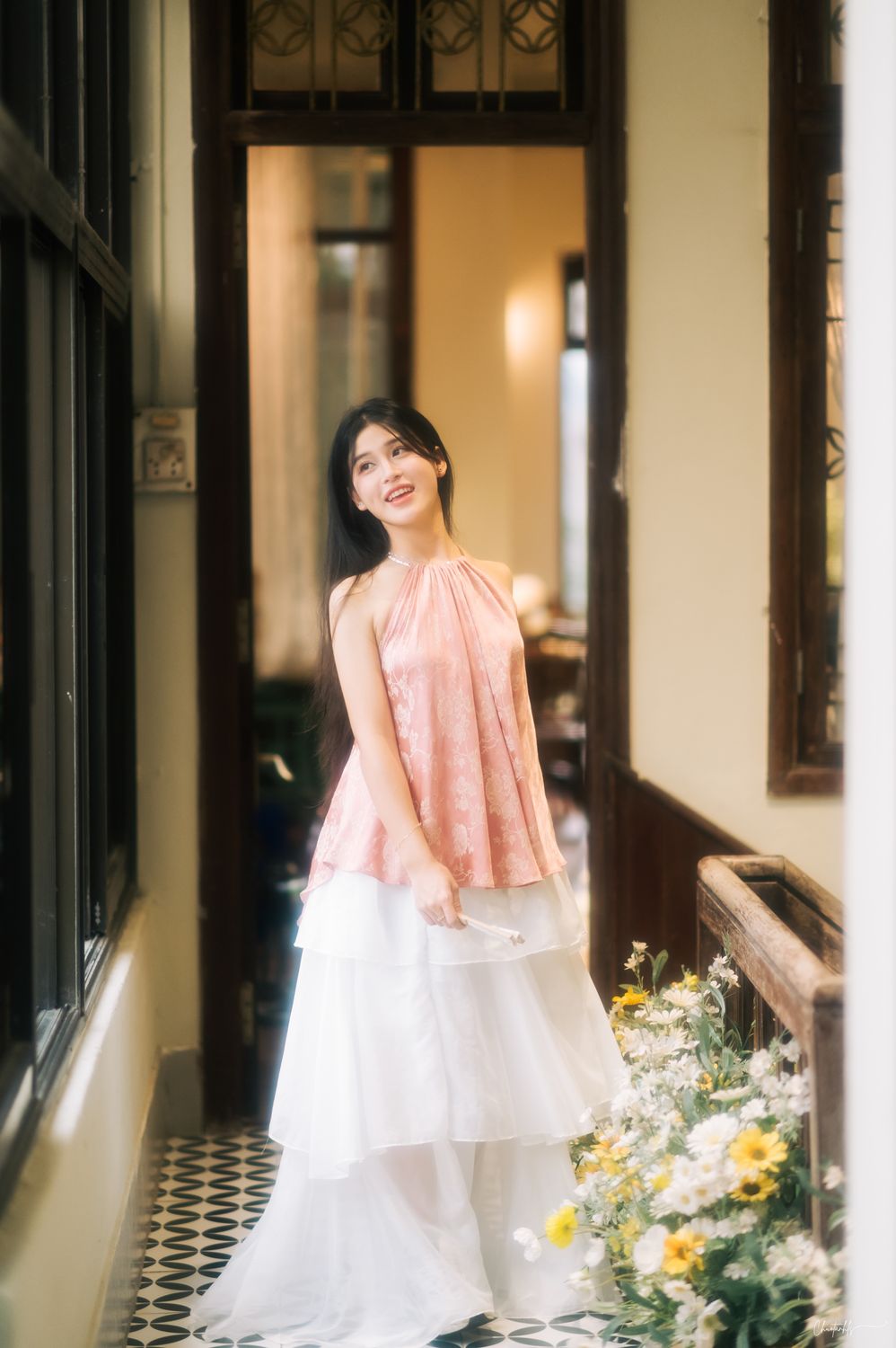 A woman in a white and pink dress stands in front of a door · Free ...