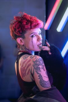 Vibrant portrait of a tattooed woman in Ciudad de México with neon lights.