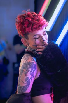 A striking portrait of a woman with red hair and tattoos, captured in vibrant neon lights, exuding a punk aesthetic.