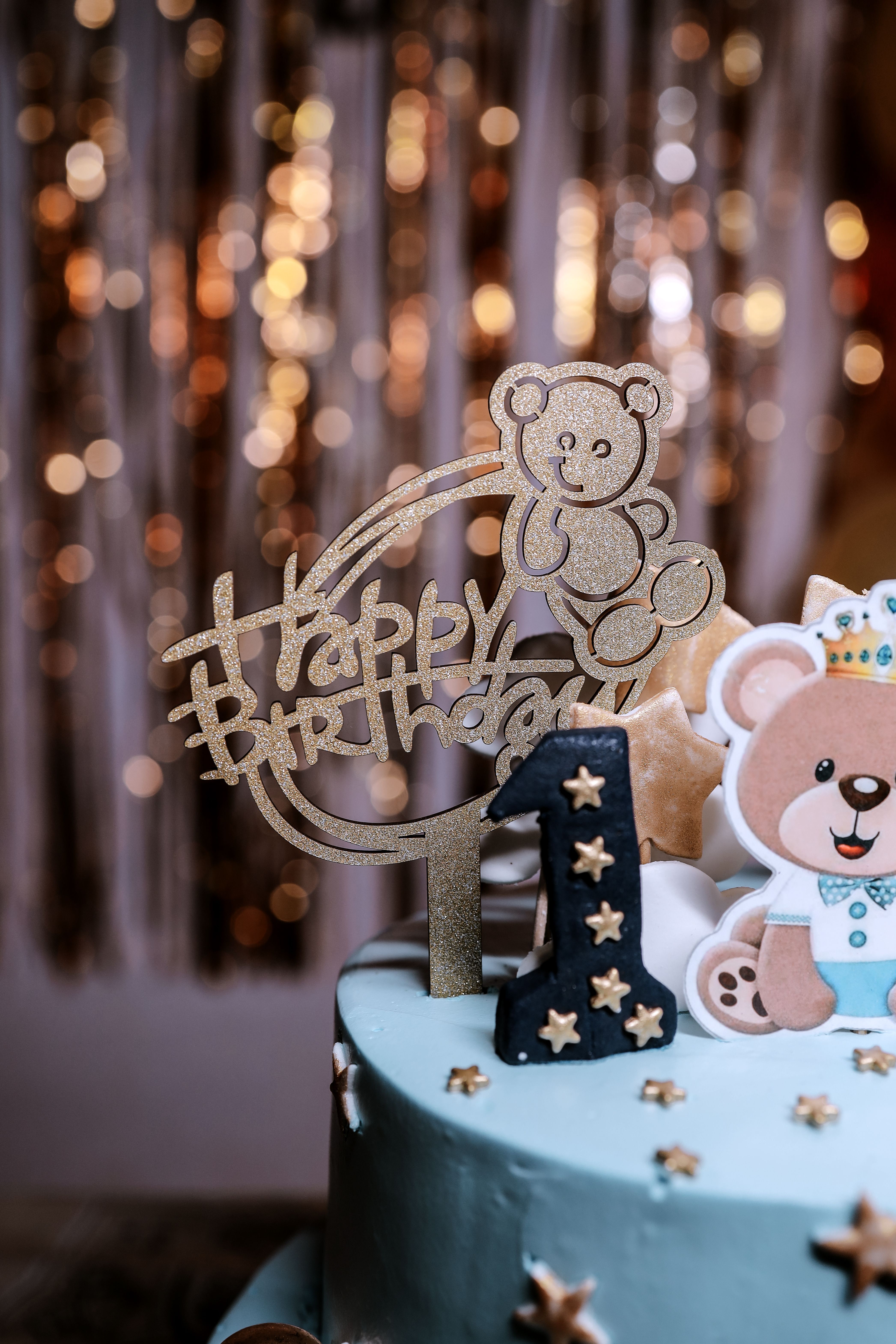 Charming first birthday cake with bear theme decoration and Happy Birthday sign.