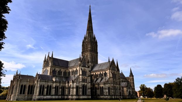 Stunning view of Salisbury Cathedral with its iconic gothic architecture against a vibrant sky.