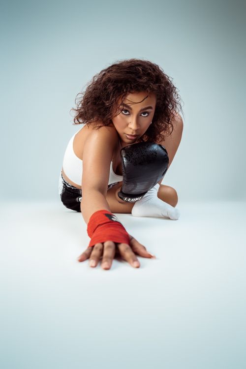 Free Striking portrait of a young female boxer posing confidently in a studio setting. Stock Photo