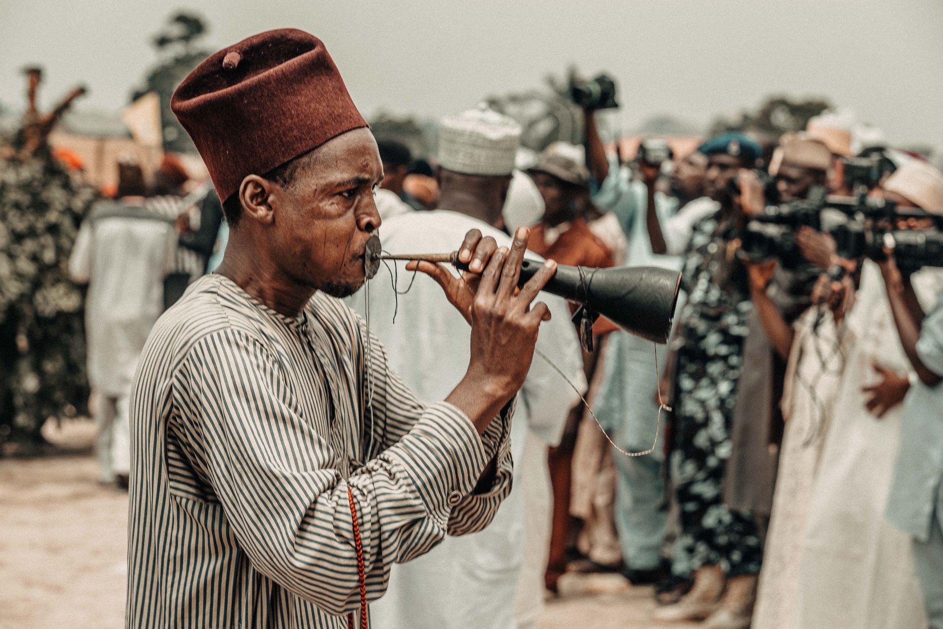 A musician in traditional attire plays an instrument during a cultural festival in Zaria, Nigeria.