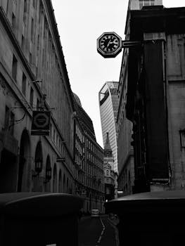 Black and white photo capturing the Walkie Talkie building from a narrow street in London, England.