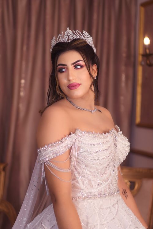 Free A beautiful adult woman in a glamorous wedding gown with intricate details and a sparkling tiara. Stock Photo