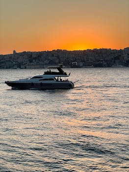 A luxury yacht sails during sunset in Istanbul, offering a serene seascape view.