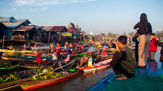 Vibrant scene of Banjarmasin's floating market with boats and locals at sunrise.