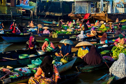 Colorful floating market in Banjarmasin with local merchants selling fresh goods at sunrise.
