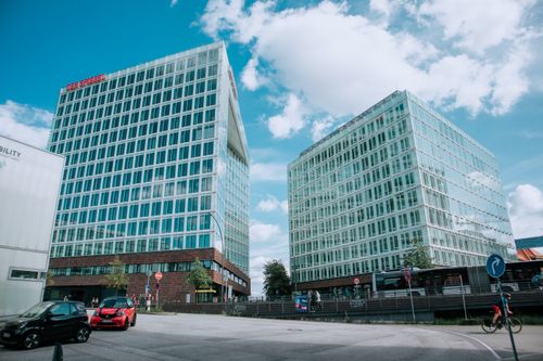 Free Contemporary glass buildings in a vibrant urban downtown setting with clear skies. Stock Photo