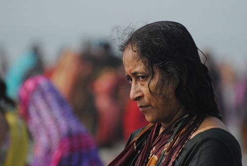 Free A woman in traditional Indian attire surrounded by a colorful crowd, depicting a contemplative moment. Stock Photo