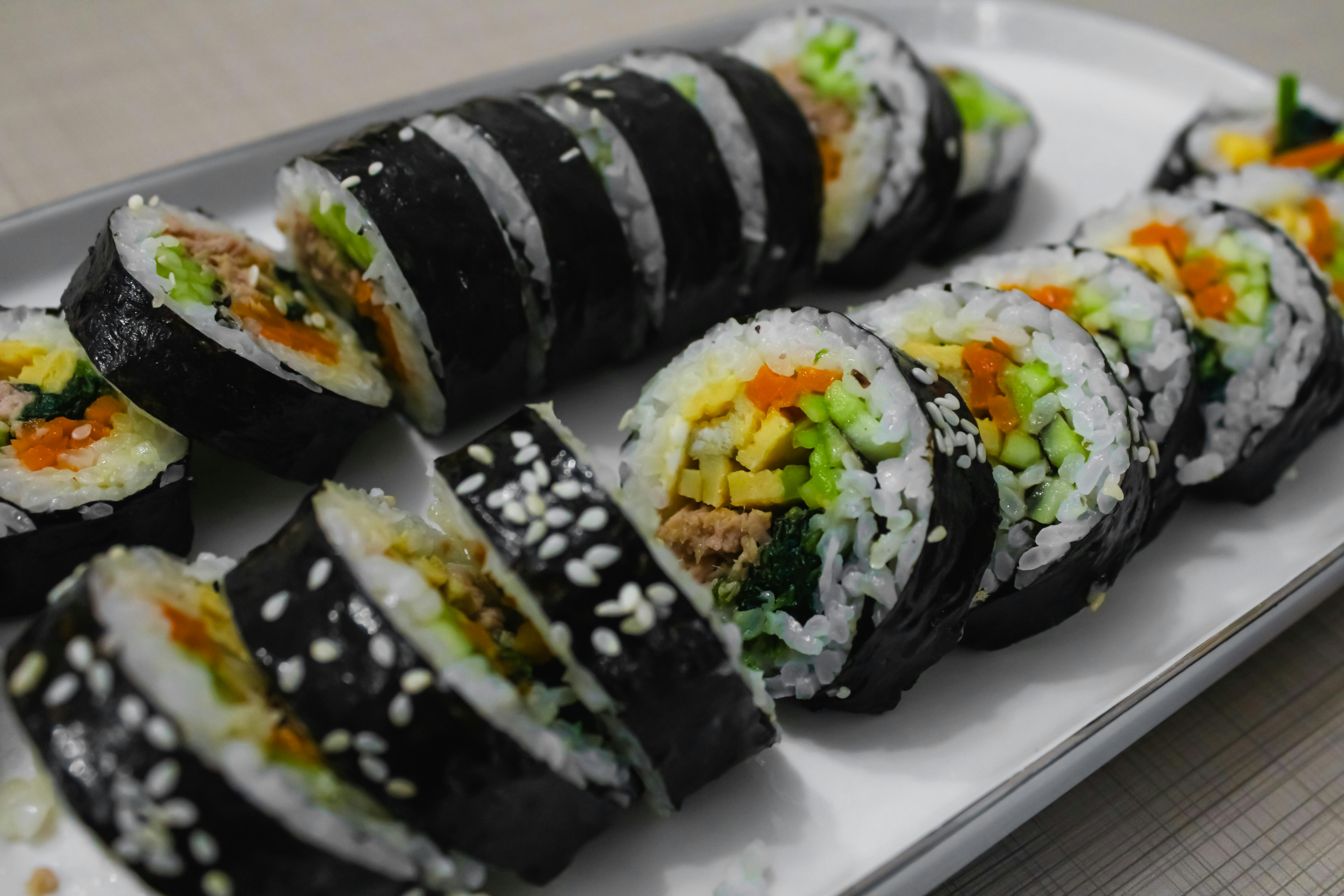 a plate of sushi with vegetables and meat