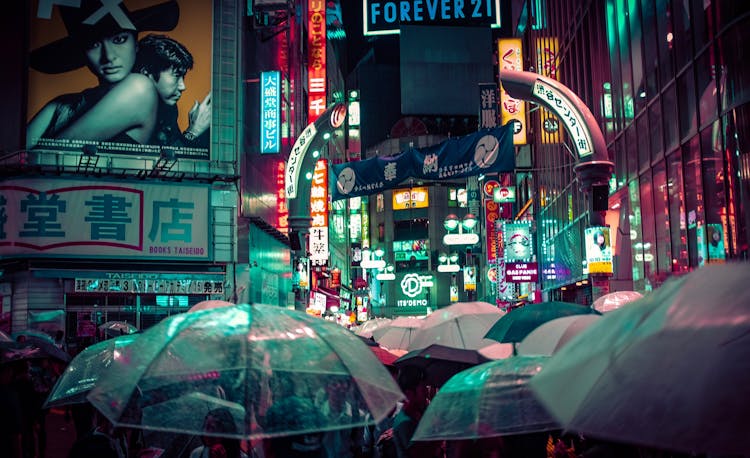 People Near Buildings During Nighttime With Lights