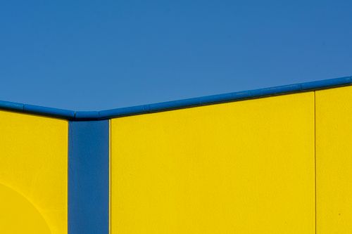Free Minimalist architectural photo of a yellow and blue building facade under a clear sky. Stock Photo