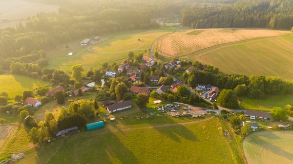 Aerial view of a small village surrounded by trees · Free Stock Photo