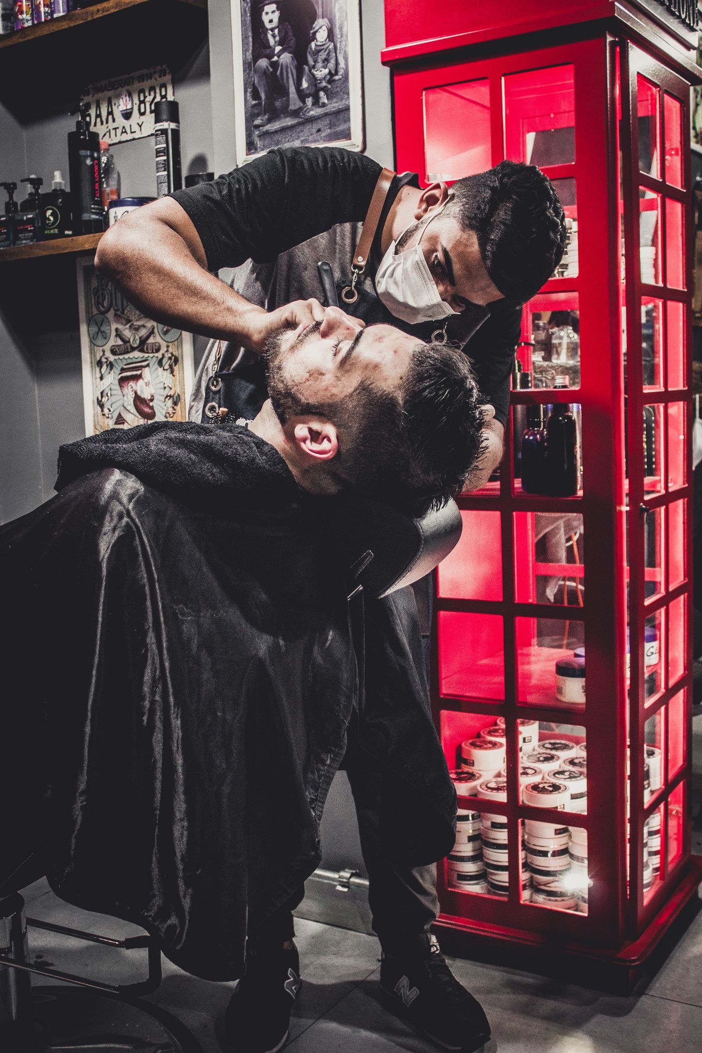 Barber performing precise scissor work in the studio
