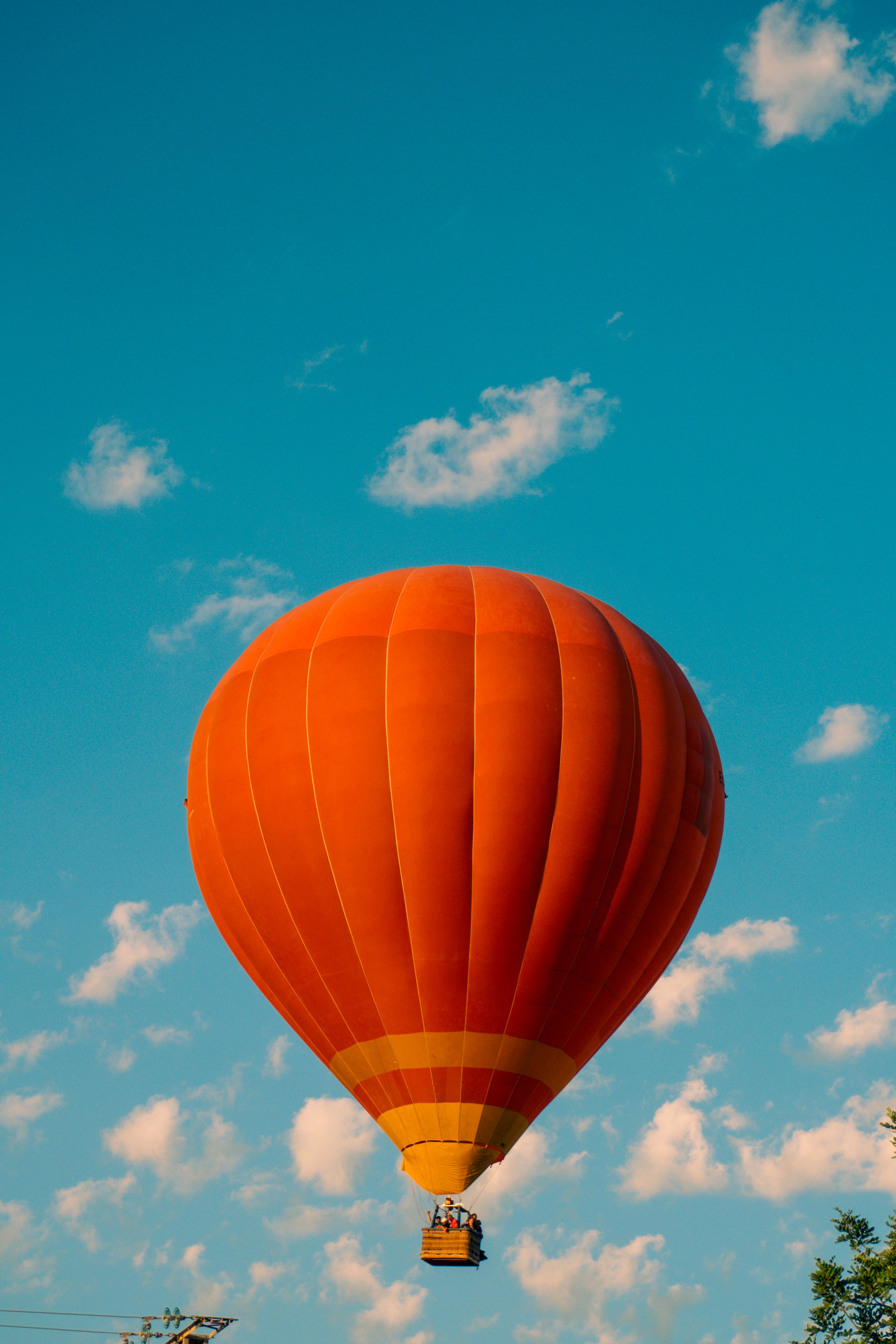 A hot air balloon flying in the sky with clouds · Free Stock Photo