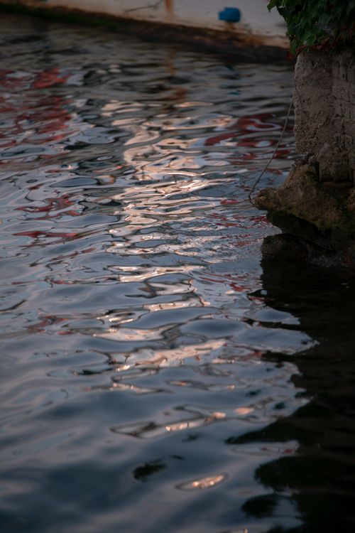 Free Serene reflections in water at dusk, capturing a tranquil evening by the shore. Stock Photo