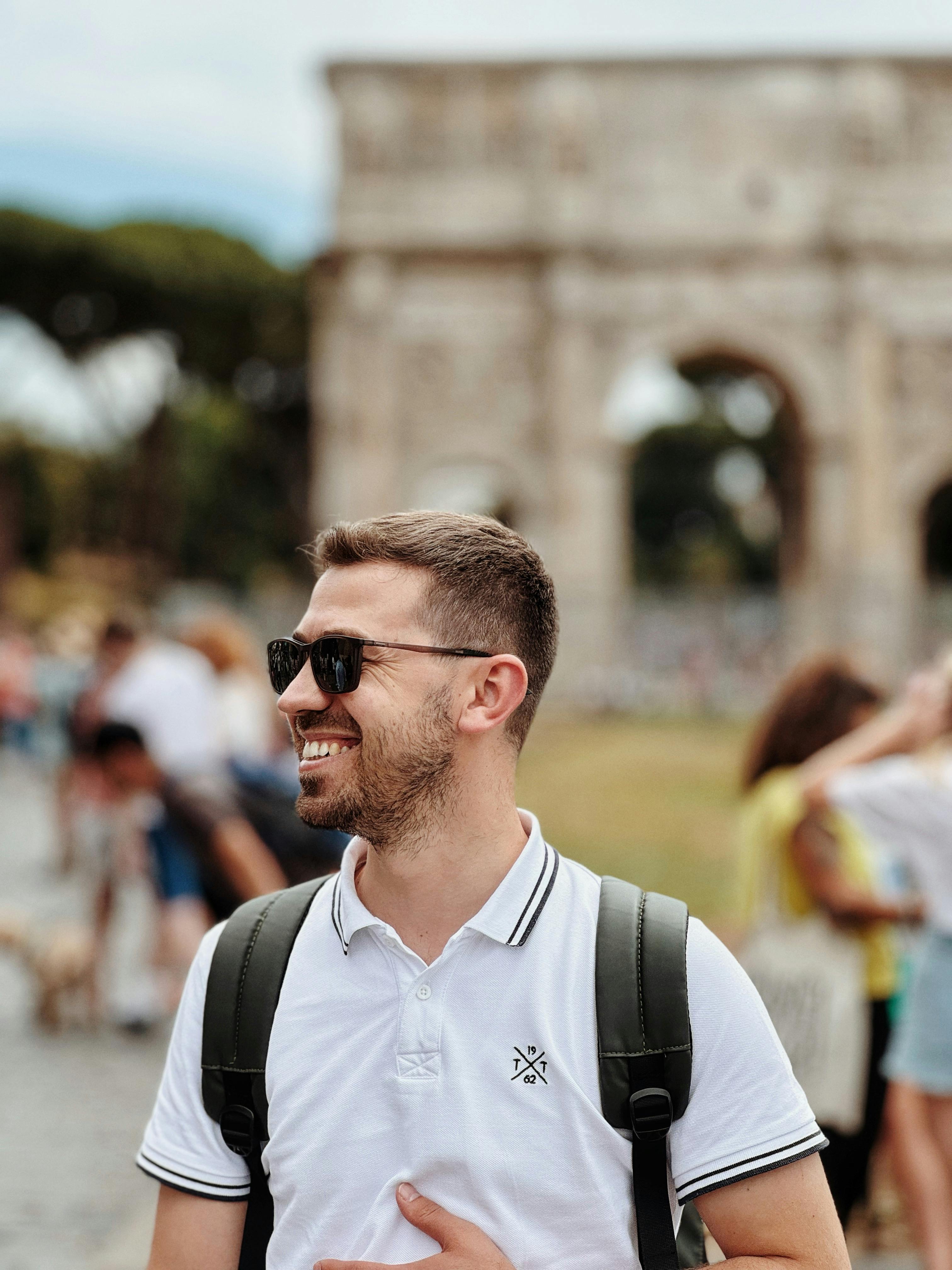 a man in a white shirt and sunglasses is smiling