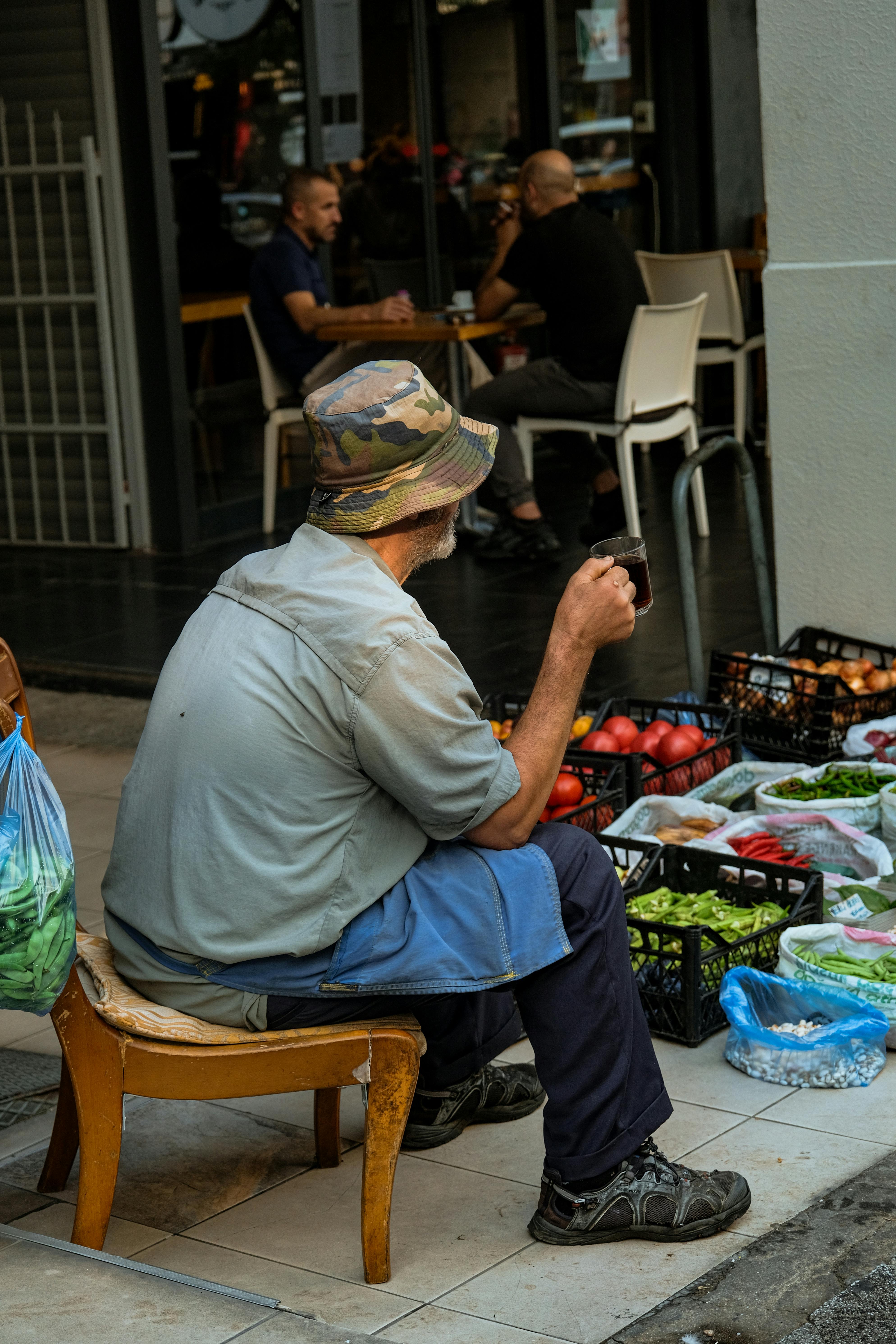 a man sitting on a chair next to a table with vegetables