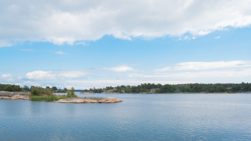 Free Serene summer landscape of Trosa archipelago with calm waters and lush greenery. Stock Photo