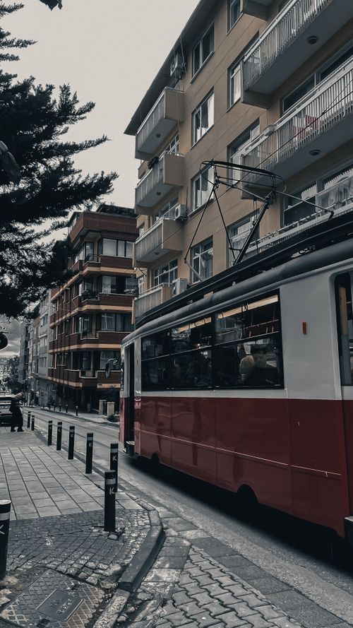 Free A classic red tram travels through a busy urban street, capturing the essence of city life. Stock Photo