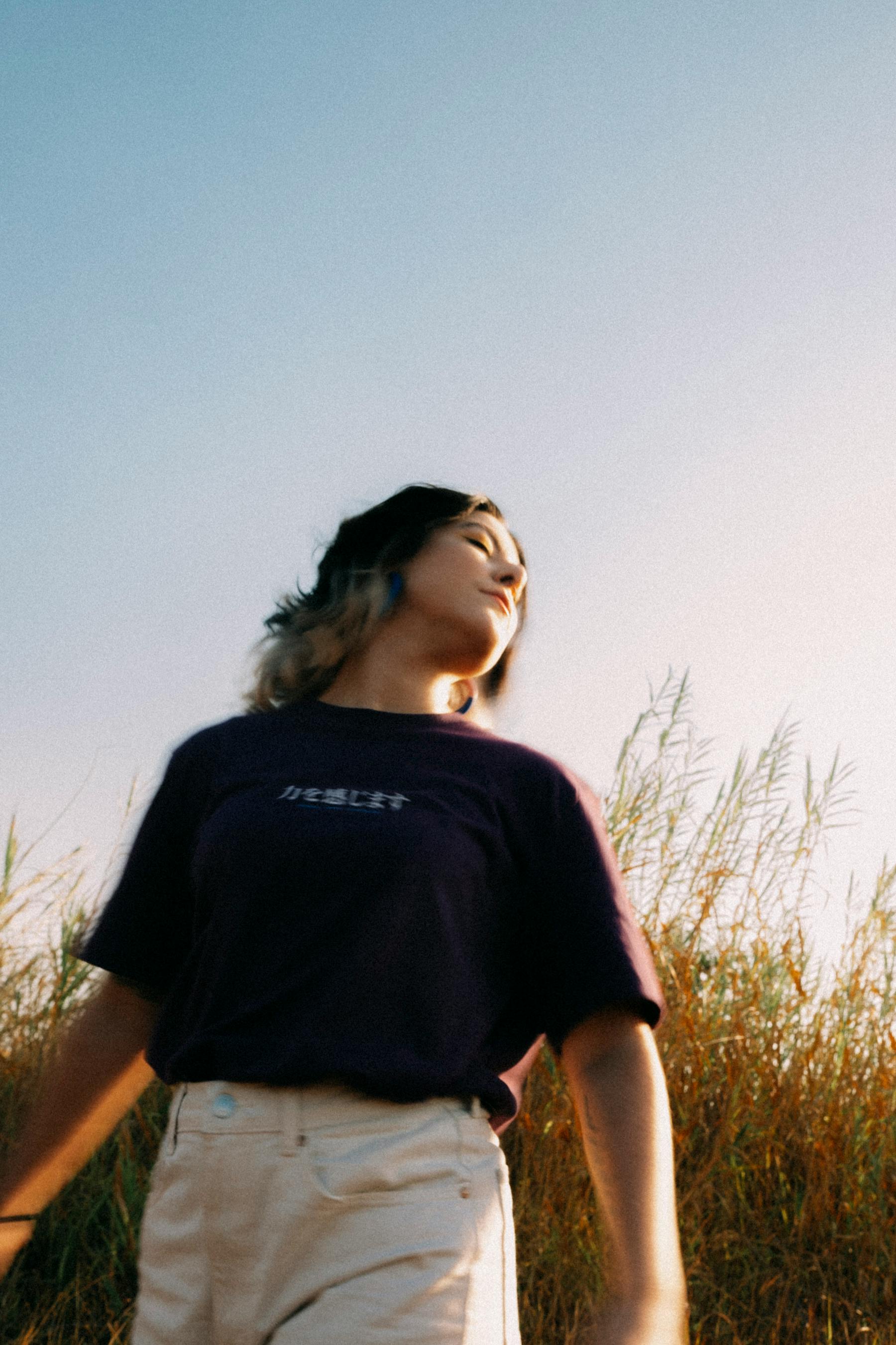 A serene portrait of a woman standing in a Brazilian field at sunset.