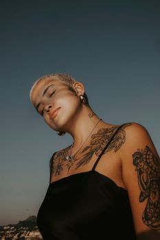 Portrait of a tattooed woman outdoors in Brazil with elegant style under a clear sky.