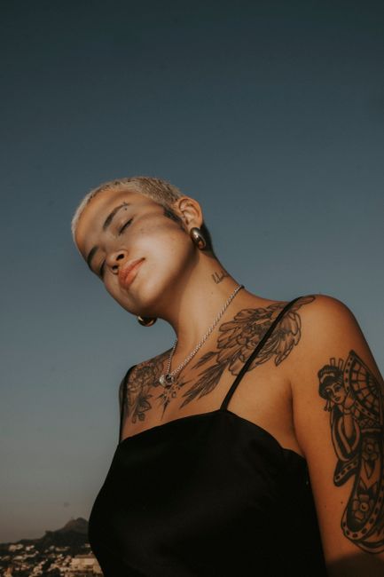 Portrait of a tattooed woman outdoors in Brazil with elegant style under a clear sky.