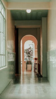 A serene corridor with an arched doorway and decorative plant.