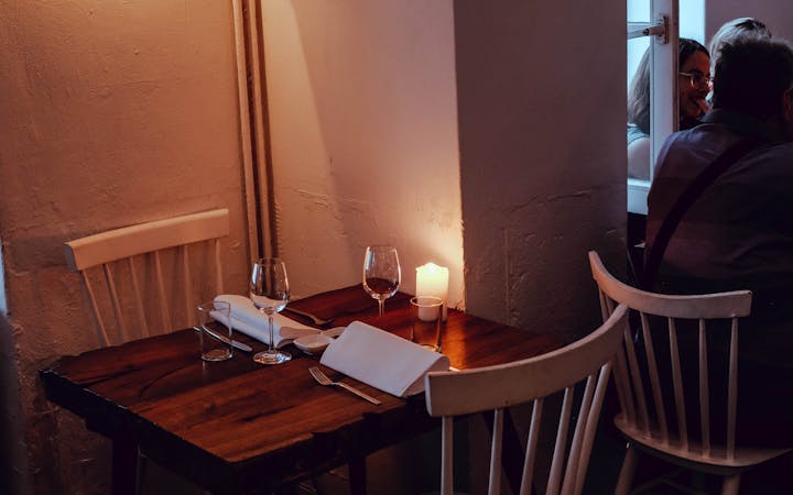 Intimate dining setup with candlelight in a cozy restaurant corner, perfect for a romantic dinner.