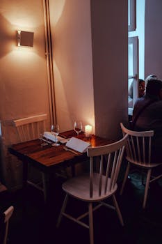 Intimate dining setup with candlelight in a cozy restaurant corner, perfect for a romantic dinner.
