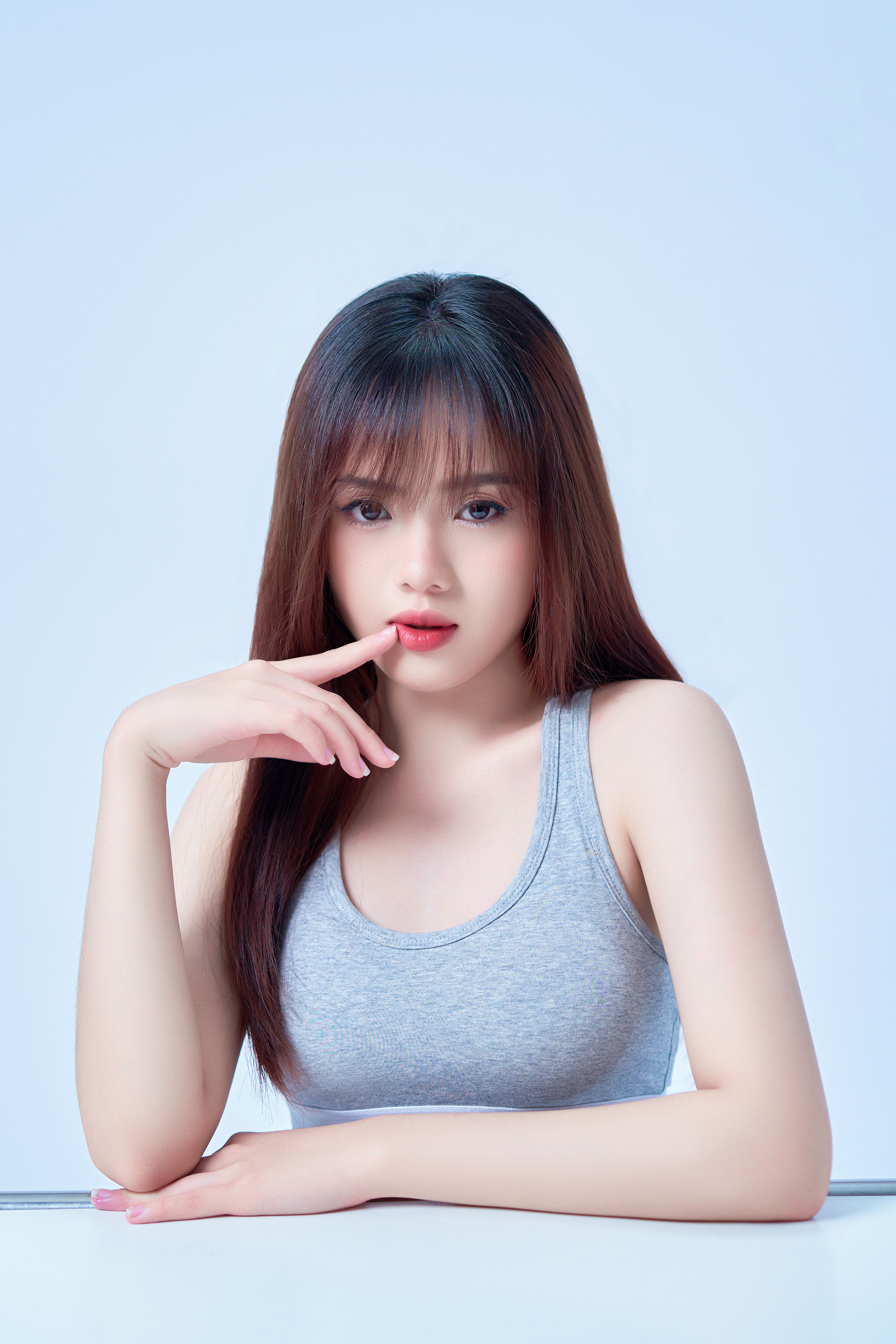 Stylish portrait of a woman with long hair posing against a bright blue background in a minimalistic style.