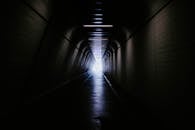 隧道光线昏暗，尽头却灯火通明，营造出一种神秘的氛围