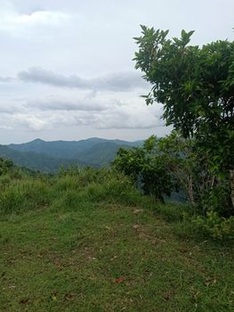 Tranquil view of lush green hills and cloudy sky, perfect for nature lovers.