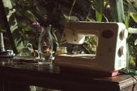 自然光透过窗户，照在木桌上的老式缝纫机上