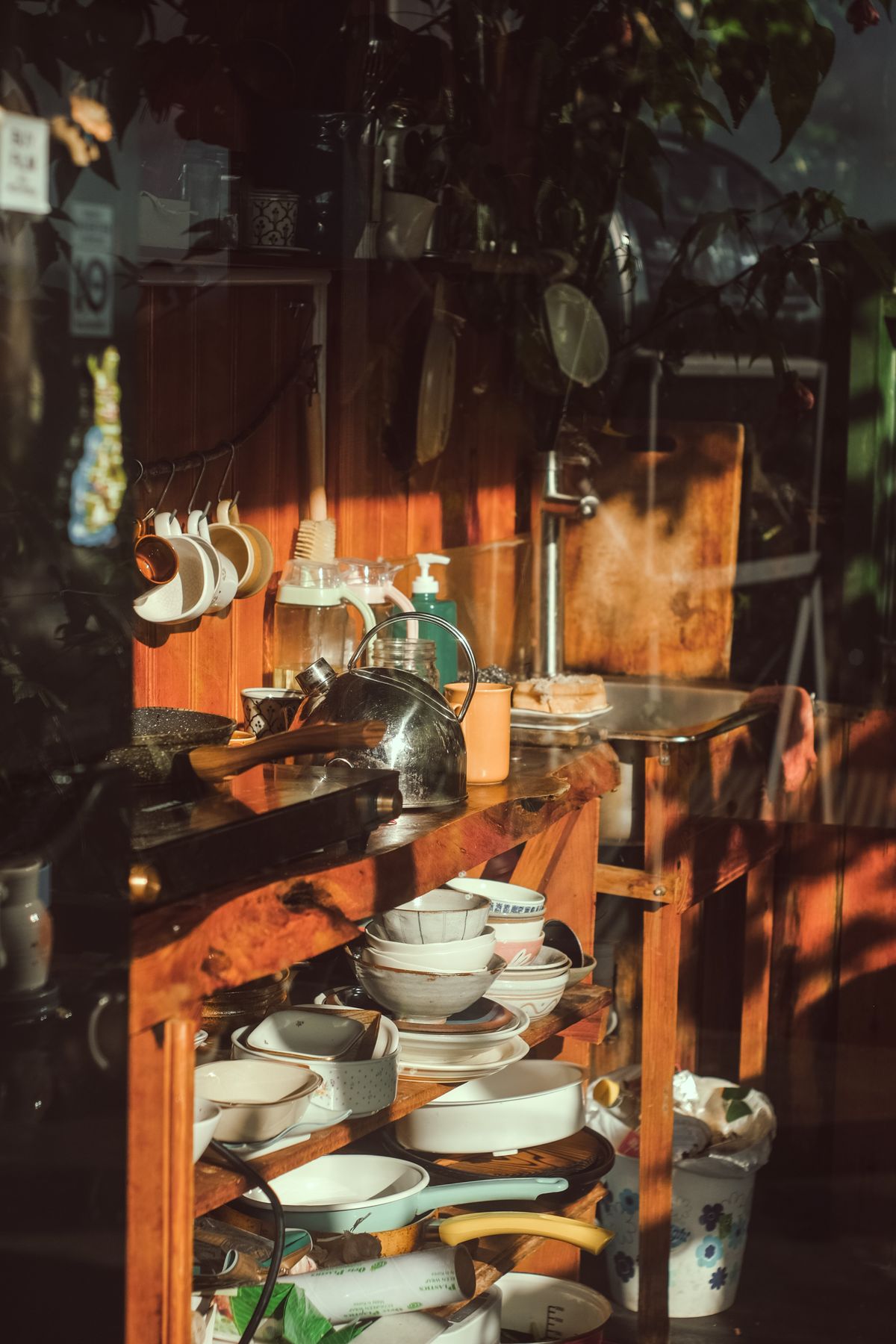Sunlit cookware, bowls, plates, and kitchen objects arranged in a real kitchen setting