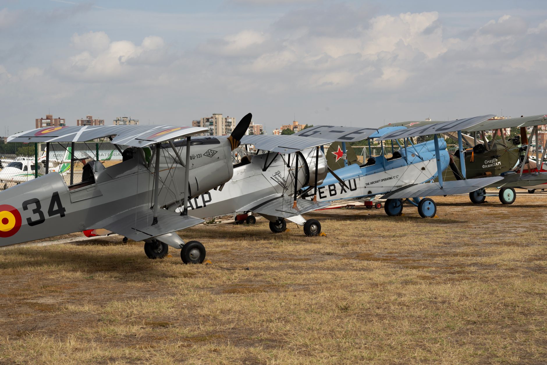 Vintage biplanes parked at a Madrid airfield, showcasing aviation history.