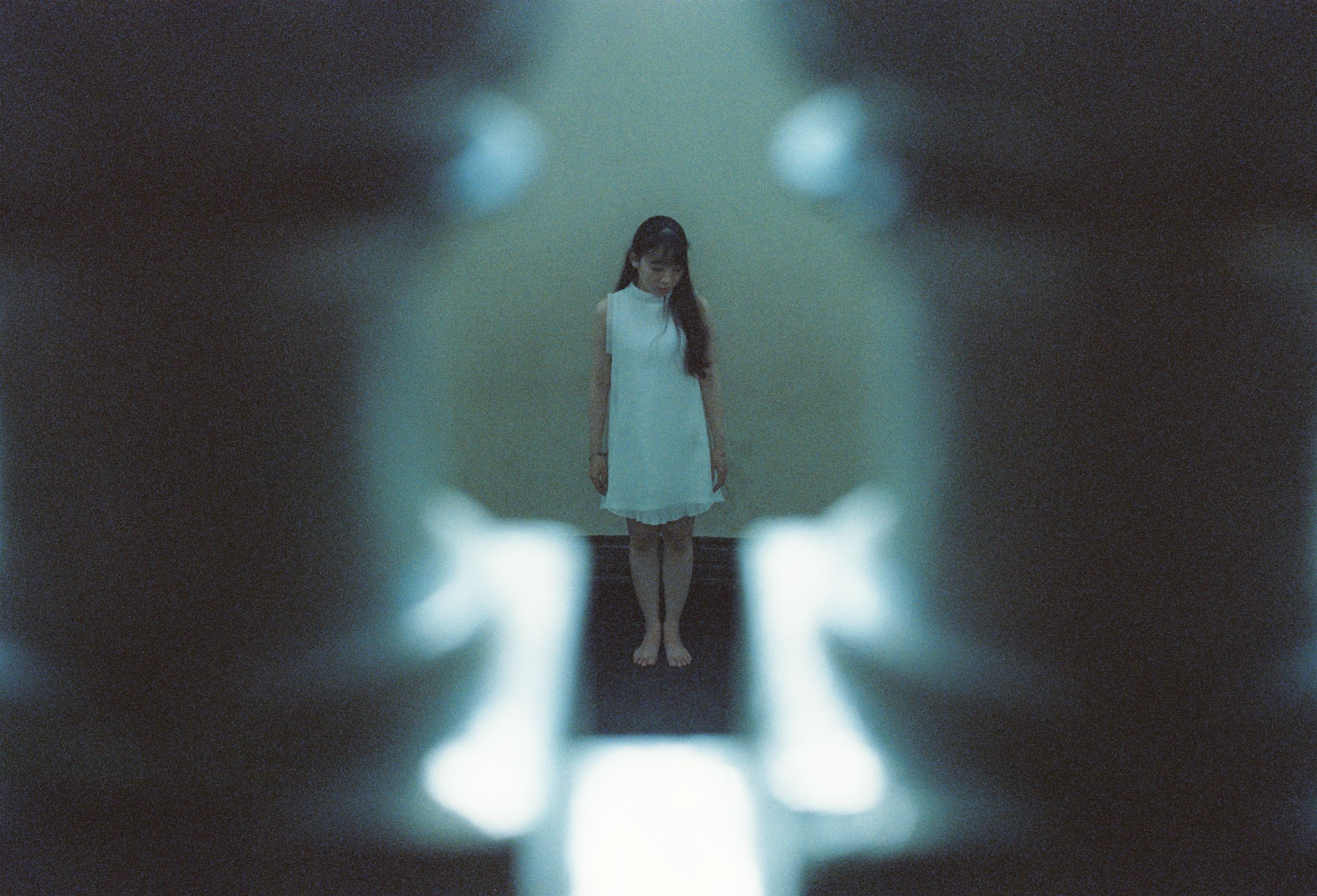 A woman standing in a dark room with a light shining on her · Free ...