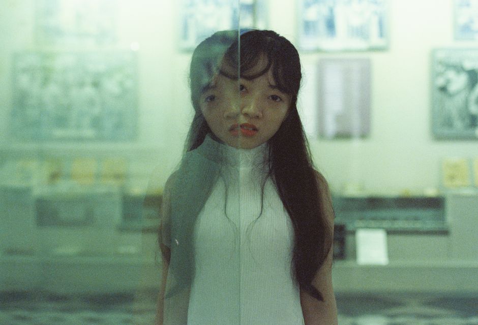 Creative portrait of a woman with reflective effects captured indoors, blending subjects and moods.