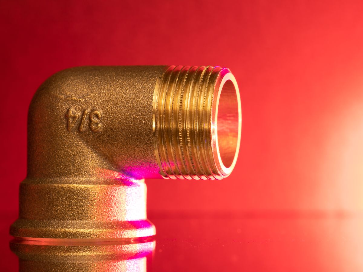 Licensed plumber fitting a copper pipe under a kitchen sink