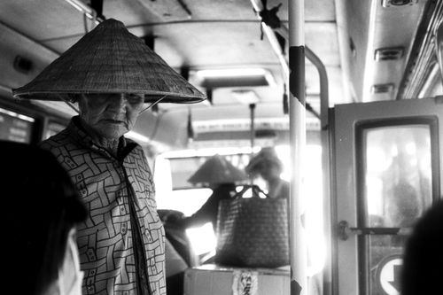 Free A black and white photo capturing people with traditional hats inside a bus, conveying cultural travel. Stock Photo