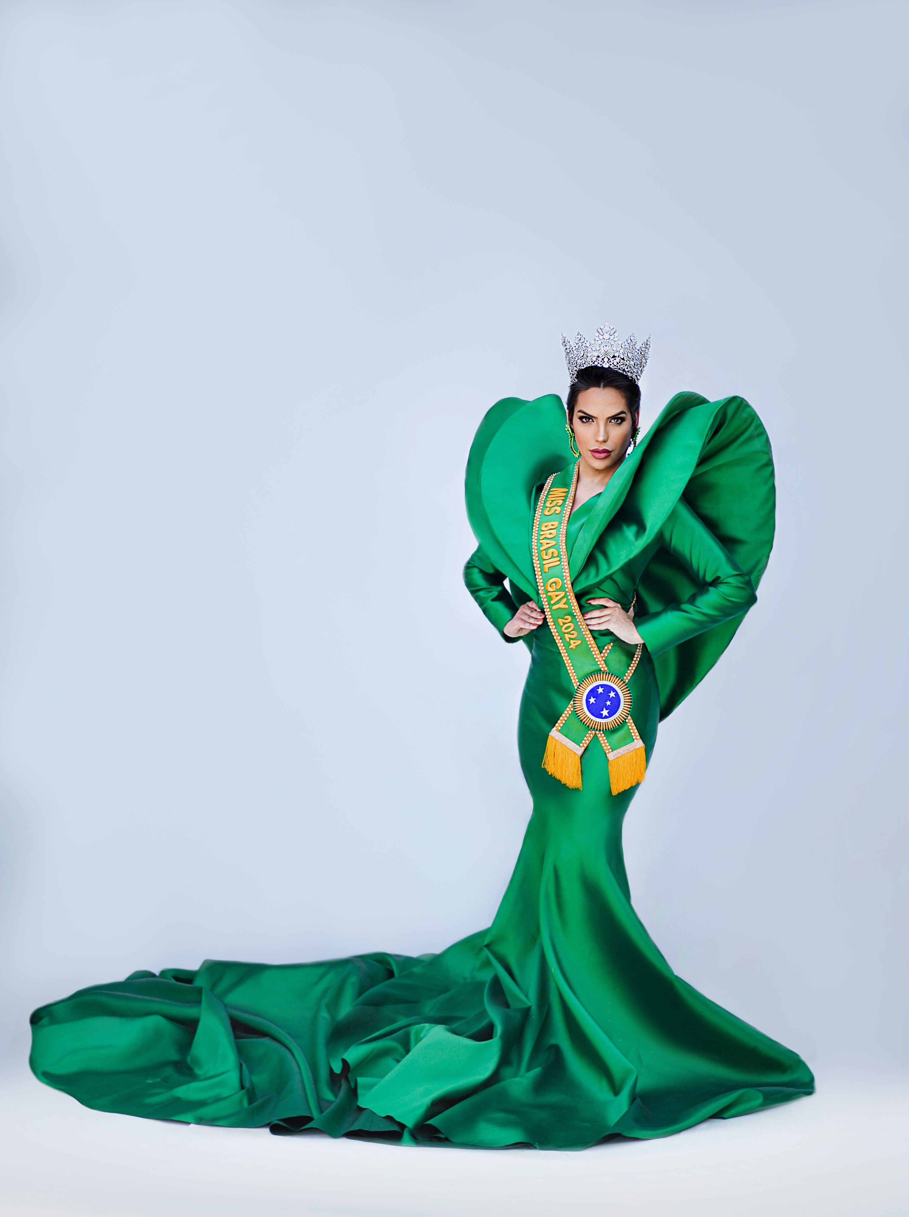 Portrait of a woman in a stunning green gown and tiara, showcasing elegance and style.