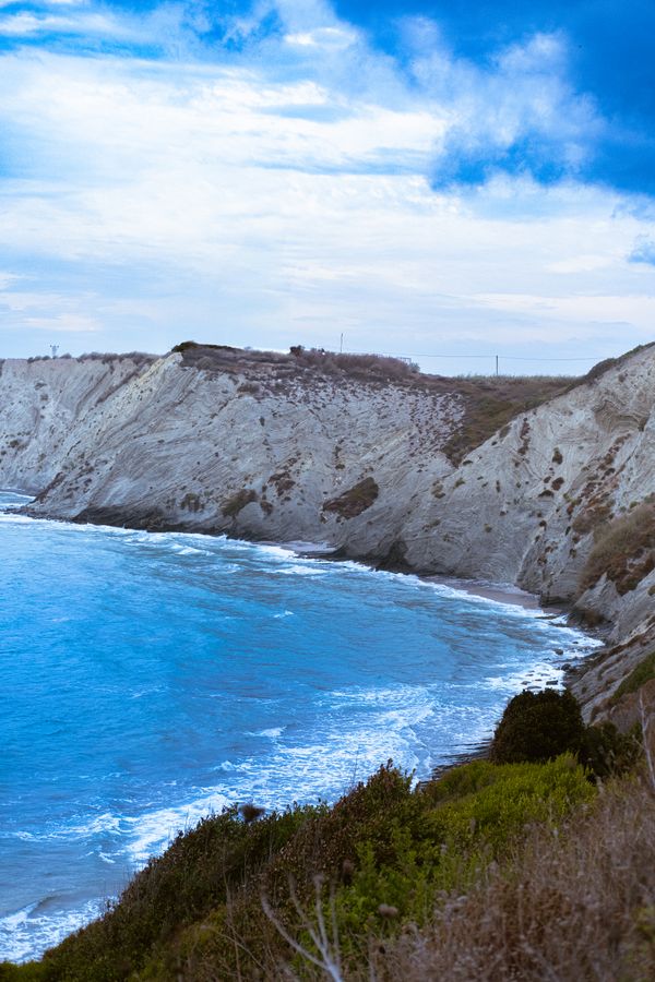 Sea cliffs above a blue bay — Barış Karagöz on Pexels